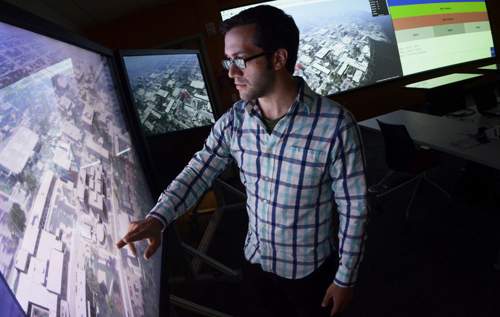 Sophomore Steven Henningsgard demonstrates the use of software being developed though a partnership with GeoComm in the St. Cloud State Visualization Lab. Photo by Adam Hammer '05