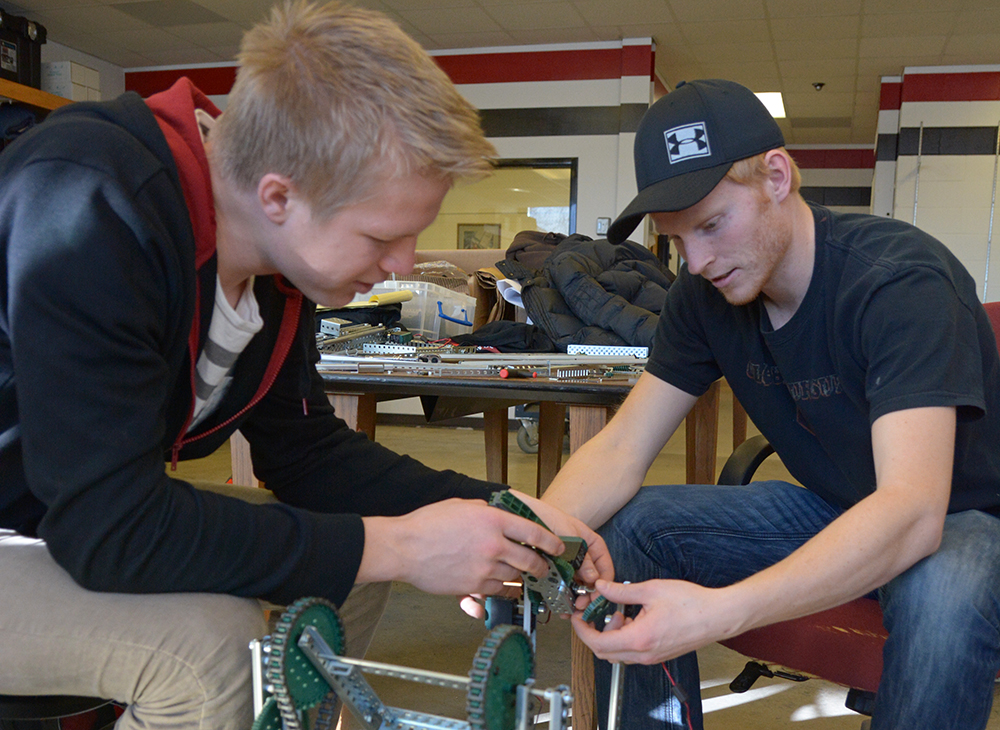 Todd Hillukka, left, and Paul Wuollet, of Husky Team 2, work on a robot for the competition. 