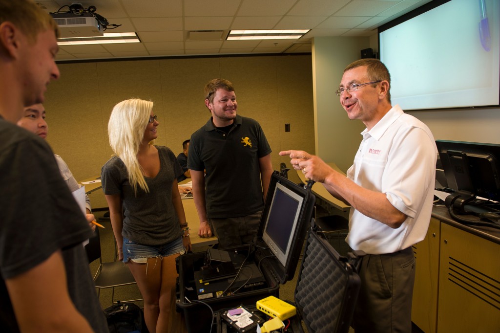 Mark Schmidt, professor of information systems, teaches students in Centennial Hall. From left are Matt Sturgeon (West Des Moines, Iowa), Megan Anderson (Hoffman) and Nathan Savering (Andover).