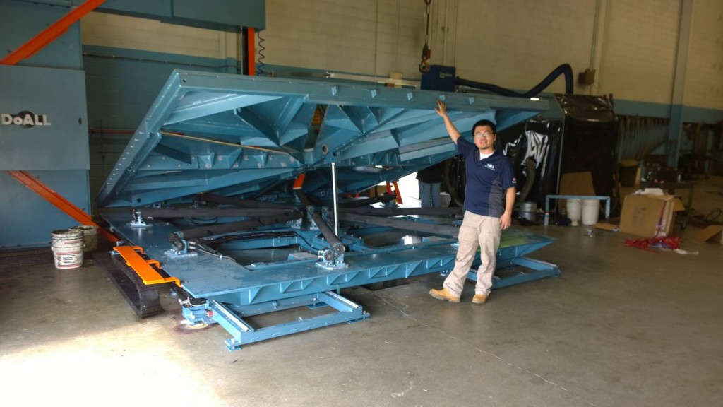 Heqiu Liu ’14 poses with one of the machines he helped engineer at Continental Machines