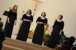 Four singers perform at the front of the church