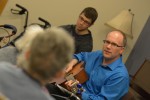 Peter Meyer plays the guitar with a student in the background