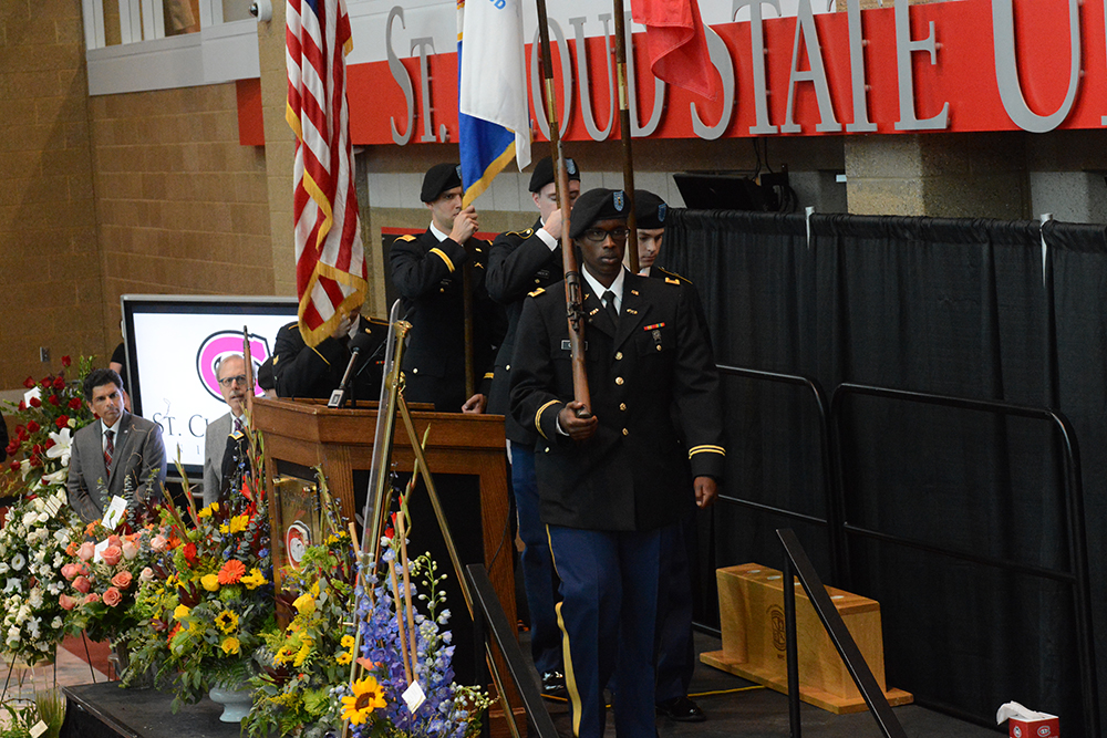 The ROTC members and officers carry the flags onto the stage