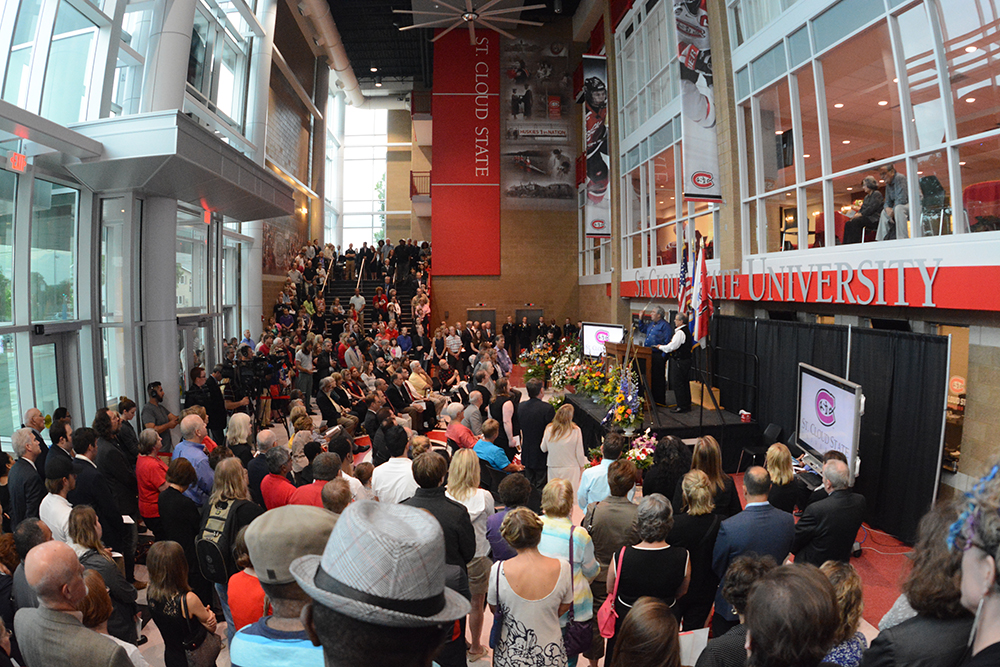 Deksi Ron Leith stands on the stage in front of a crowd of family and friends in the Herb Brooks National Hockey Center