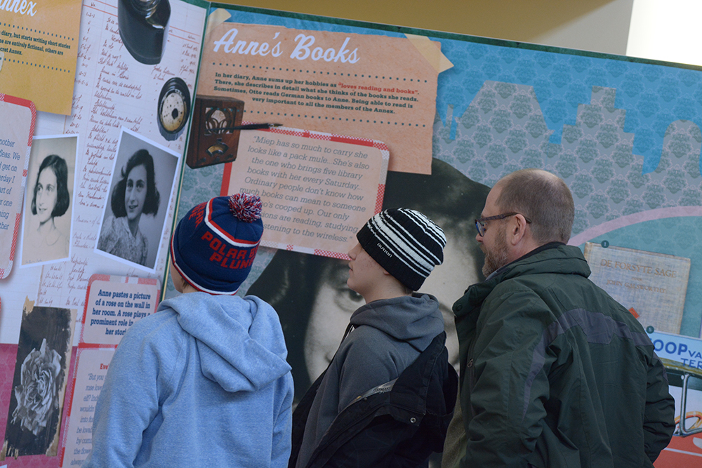 Students and a teacher read the exhibit