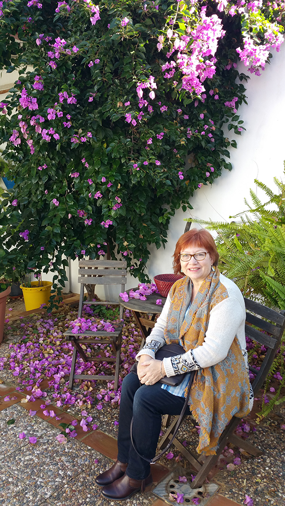 Paula Weber sitting on a bench by flowers