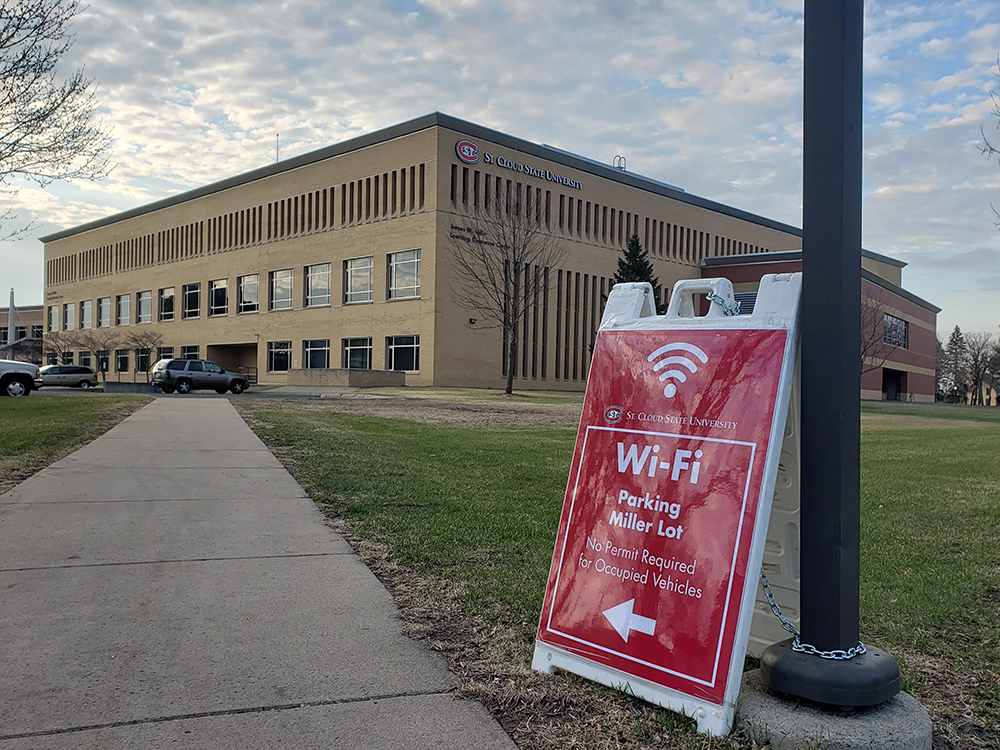 A sign pointing to the Wi-Fi parking with Miller Center in the background