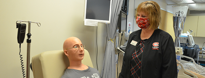 Nursing Lab Coordinator Jan Richardson working with "Alex," a full-sized patient communication simulator