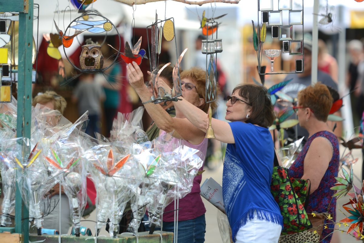 Community members observing one of the over 150 vendors present at the 49th annual Lemonade Concert and Art Fair on June 23, 2022 at St. Cloud State University.