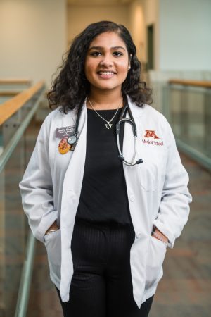 Pre-med graduate Sruthi Shankar '18 in her University of Minnesota Medical School coat, where she is now a fourth-year medical student 