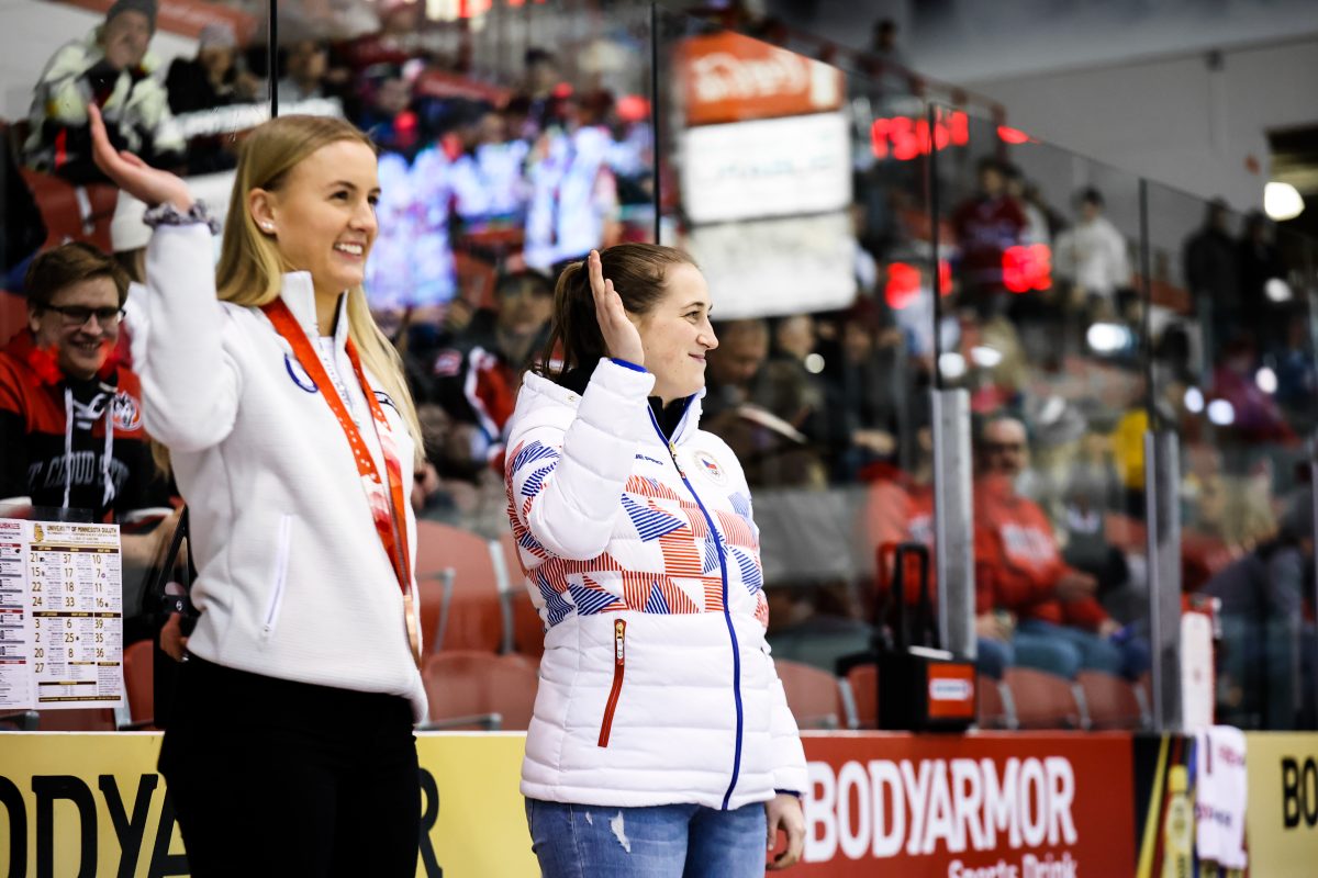 Jenniina Nylund and another athlete stand on the medal stand. 