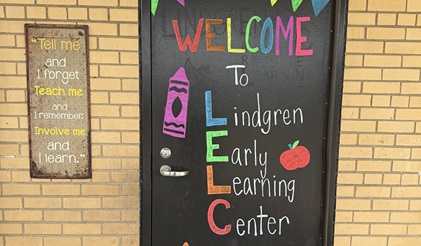 A black door with colorful words on it that reads Welcome to Lindgren Early Learning Center.
