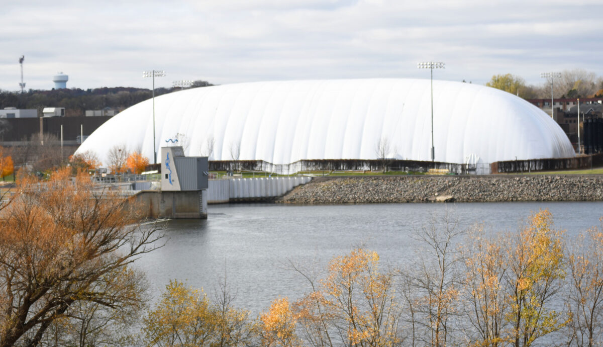 A white dome is visible across the river with water and trees visible in the foreground 