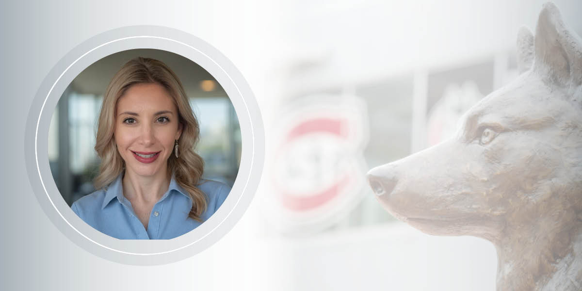 Headshot of Robin Wagner Renucci, wearing a blue shirt and smiling, framed in a circle next to the statue of a husky in Husky Plaza