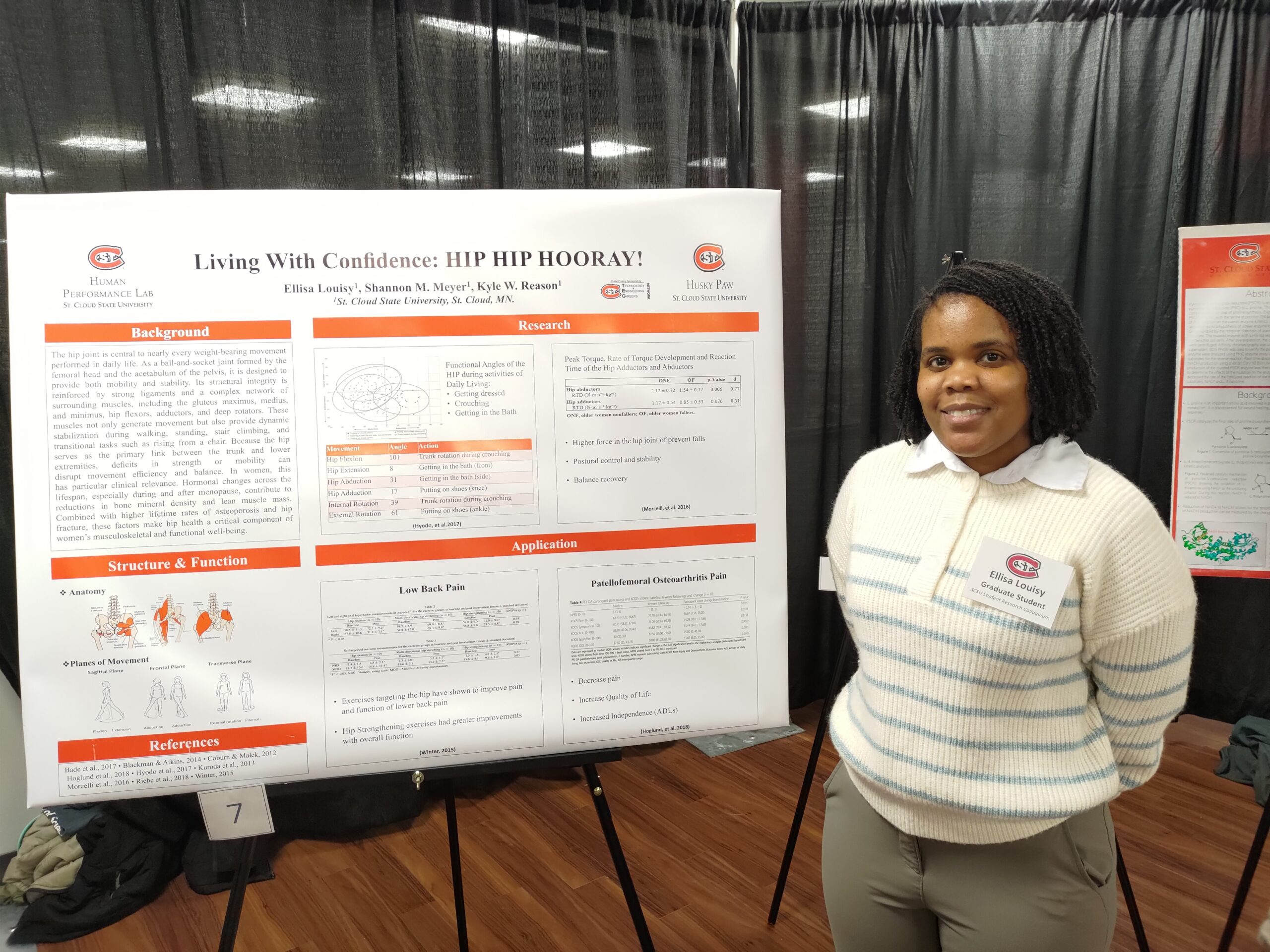 Student stands in front of presentation board.