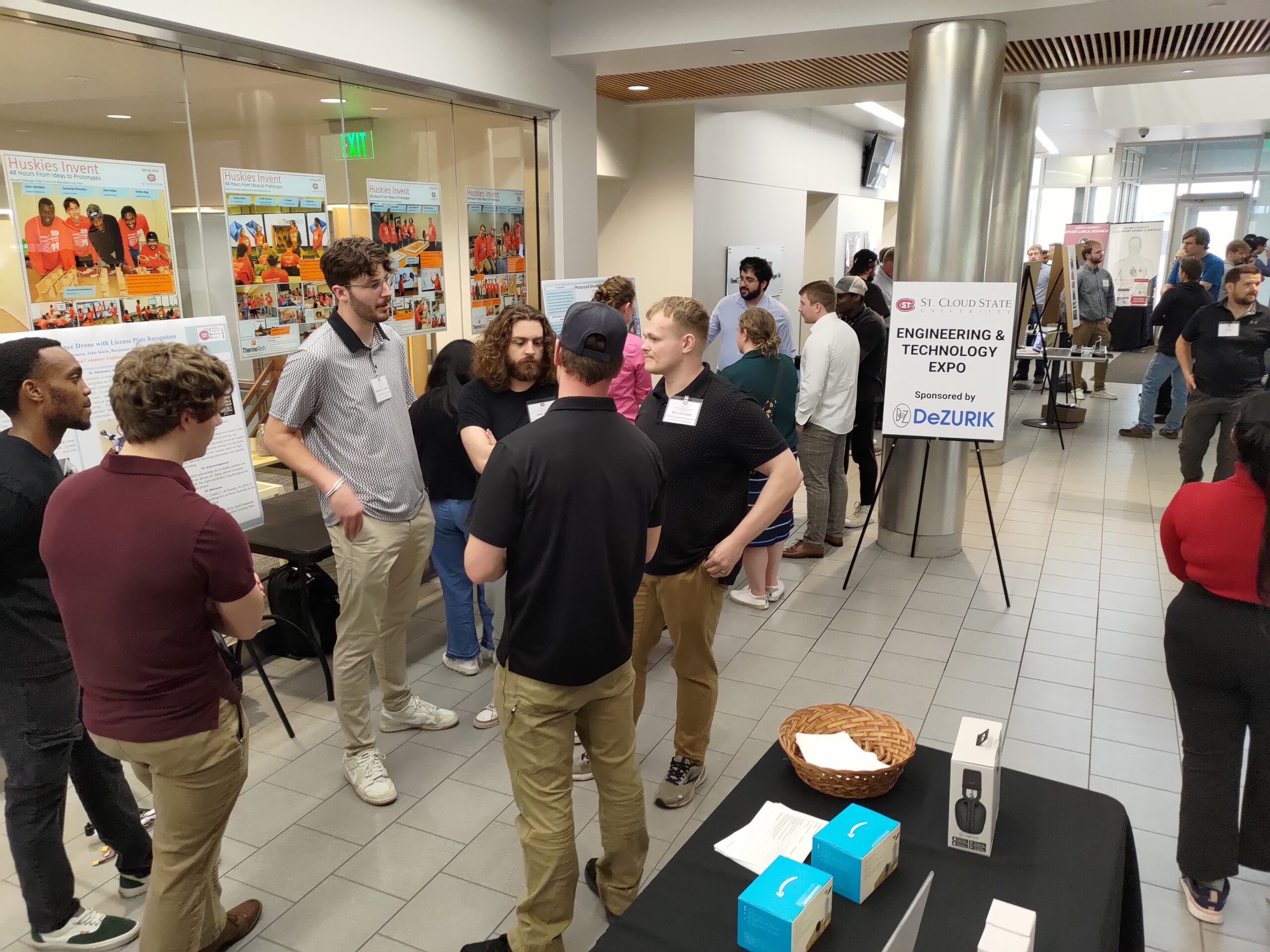 Group of people gathering around presenters.