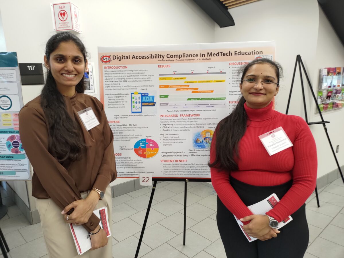 Two women standing in front of a presentation board.
