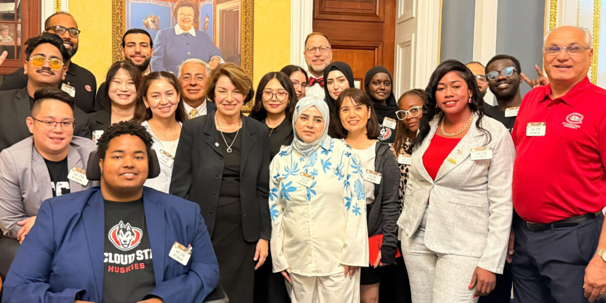 A group of 21 people smile for a group photo