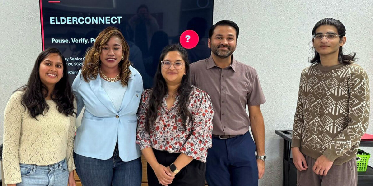Five people stand together for a photo in front of a screen for the event ElderConnect