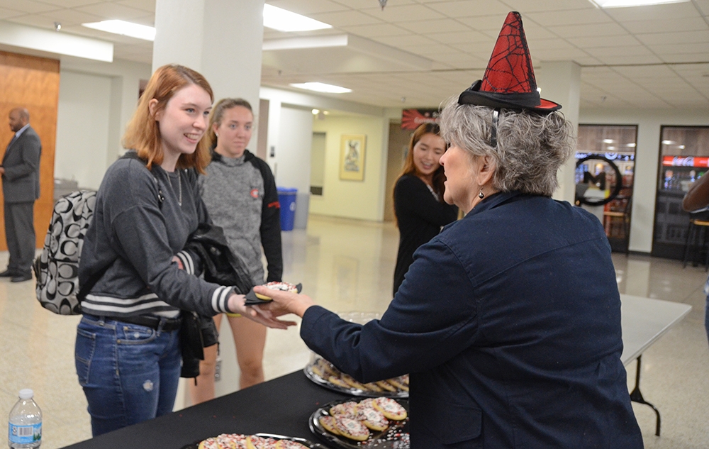 Margaret Vos handing a student a cookie