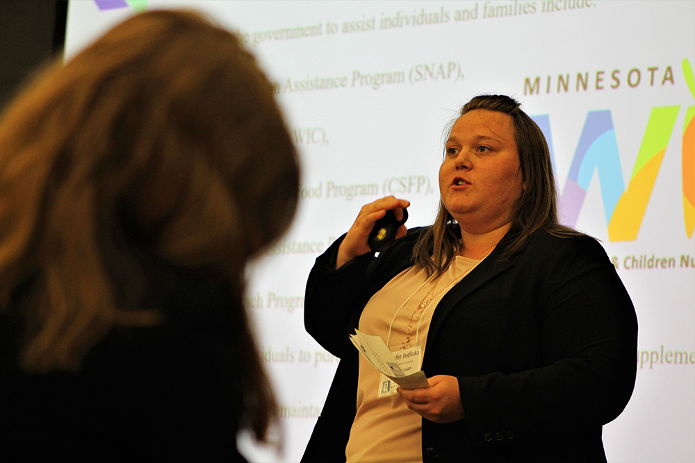 Jennifer Jedlicka presenting in front of a screen